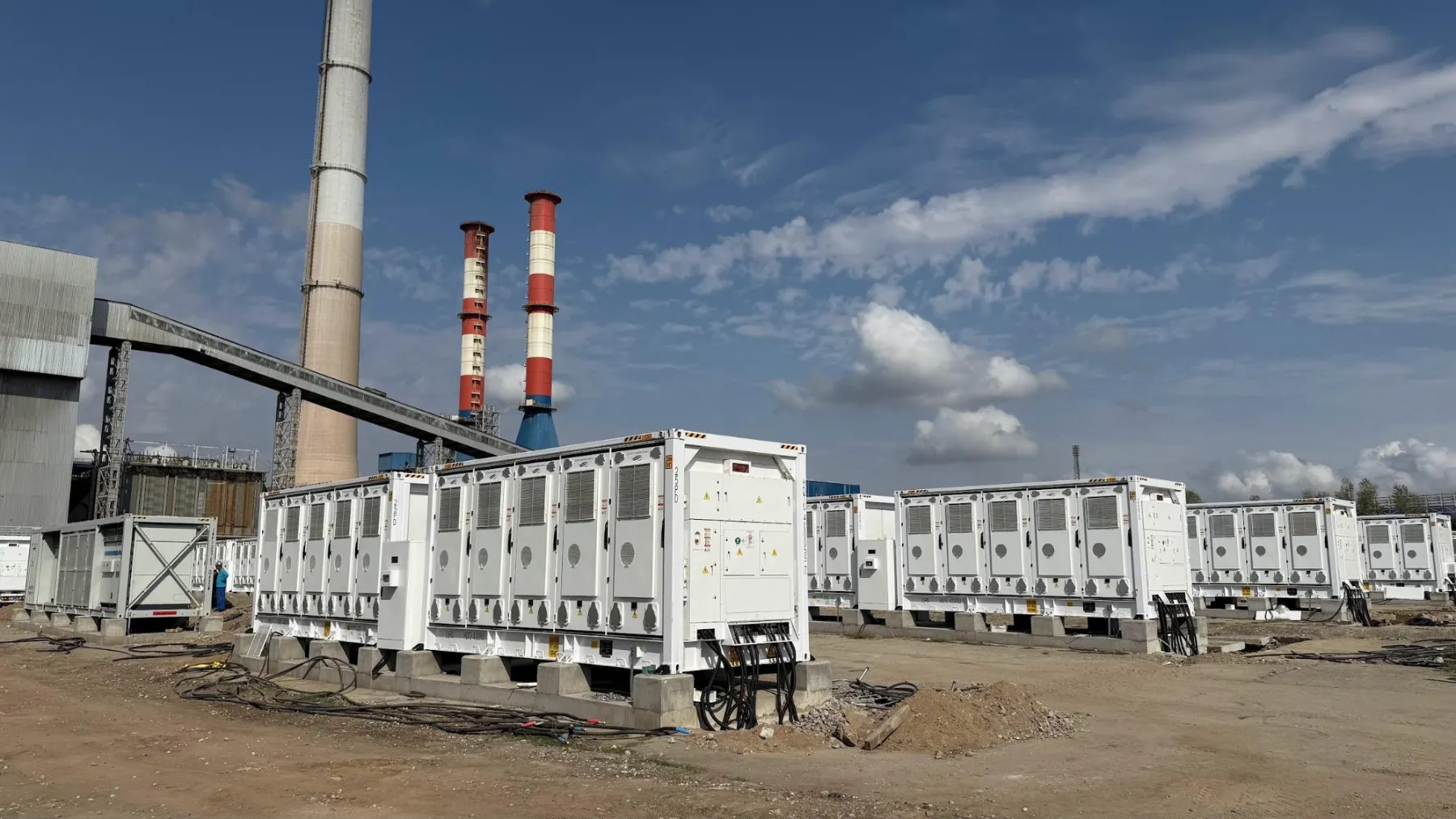 Rows of 20 ft MC Cube battery containers on an industrial site