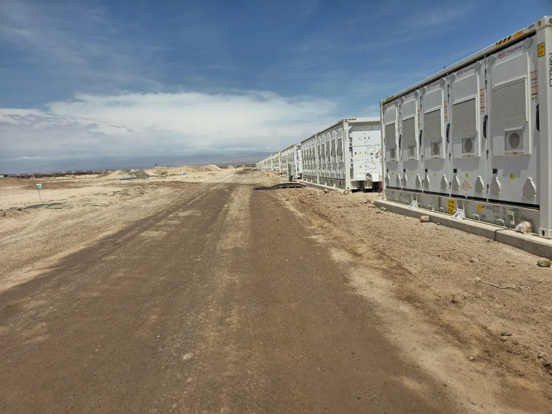 Rows of MC Cube battery containers stretching to the horizon at a utility-scale park